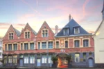 Ancien bâtiment en briques avec un coucher de soleil en arrière-plan L'Hermitage Gantois, Autograph Collection à Lille
