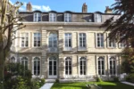 Ancienne maison en pierre avec une pelouse devant Clarance Hotel Lille