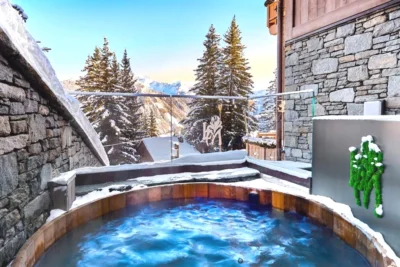 Bain à remous sur le côté d'un bâtiment dans la neige Lys Martagon à Courchevel