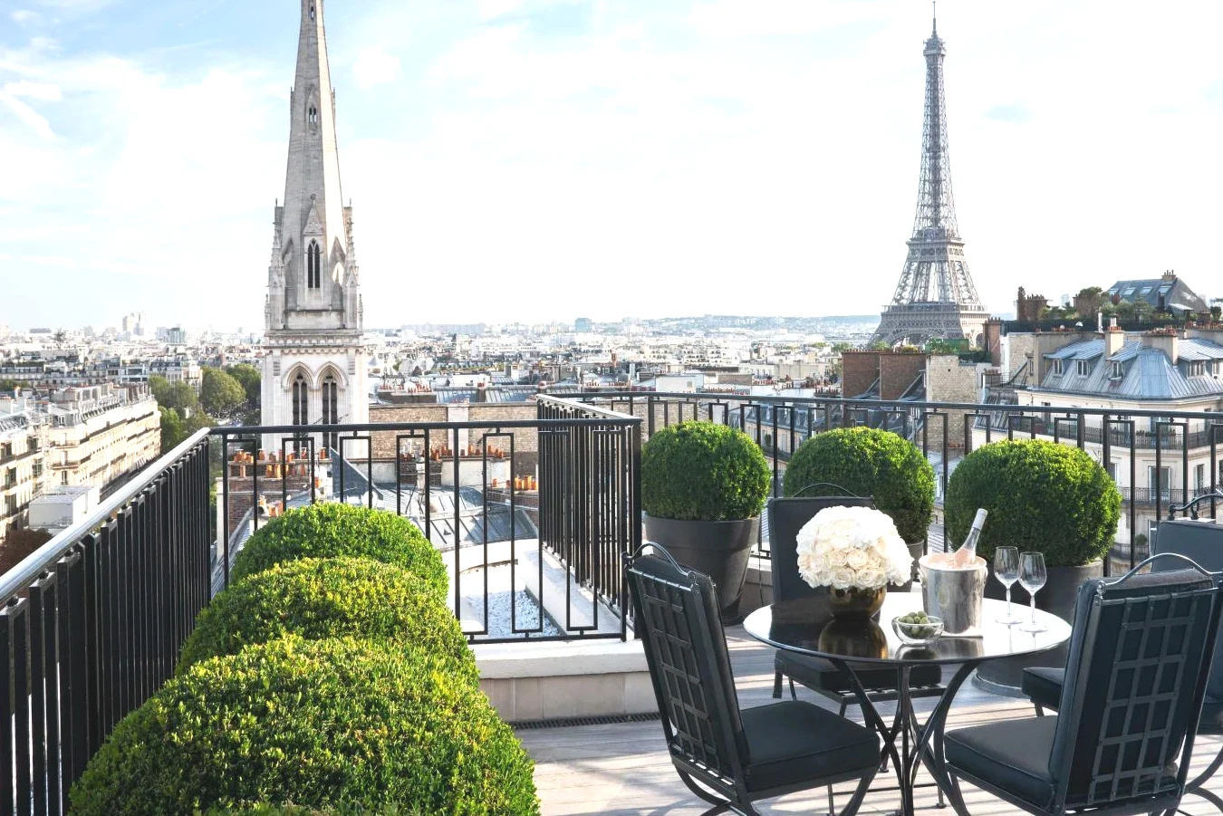 Balcon avec une table et des chaises et la tour Eiffel Four Seasons Hotel George V Paris