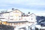 Bâtiment blanc dans la neige avec des montagnes Hotel Le Chabichou à Courchevel