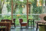 Cette chambre dispose d'une grande fenêtre avec des chaises et des tables Hôtel de Berri Champs-Élysées a Luxury Collection Hotel à Paris