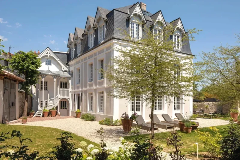 Cette grande maison blanche dispose d'une cour avec des chaises Hôtel Saint-Delis La Maison du Peintre Relais & Châteaux à Honfleur