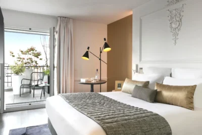 Chambre avec un grand lit et un balcon dans La Clef Champs-Élysées Paris by The Crest Collection