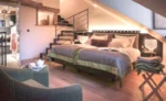 Chambre avec un lit et un escalier dans l'hôtel 5 étoiles Les Loges Annecy Vieille Ville