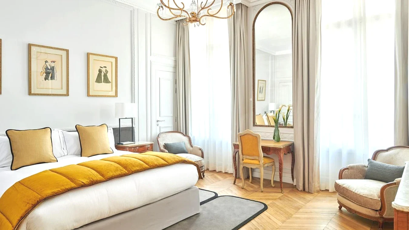 Chambre de luxe avec un lit une table et des chaises dans l' Hôtel Lancaster Paris Champs-Elysées