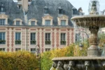 Fontaine devant un grand bâtiment Cour des Vosges Evok Collection à Paris