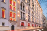 Grand bâtiment avec des fenêtres éclairées dans une rue Hotel SAX Paris LXR Hotels & Resorts
