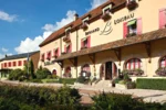 Grand bâtiment avec des fenêtres rouges et des plantes devant Relais Bernard Loiseau à Saulieu