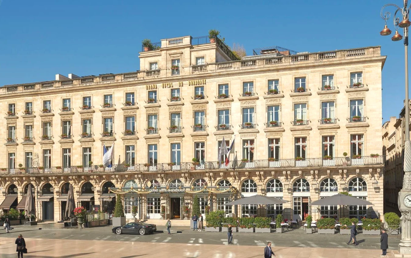 Grand bâtiment avec des gens qui marchent InterContinental Bordeaux Le Grand Hotel by IHG Grand bâtiment avec des gens qui marchent InterContinental Bordeaux Le Grand Hotel by IHG