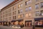 Grand bâtiment avec des tables et des chaises devant La Caserne Chanzy Hotel & Spa Autograph Collection à Reims