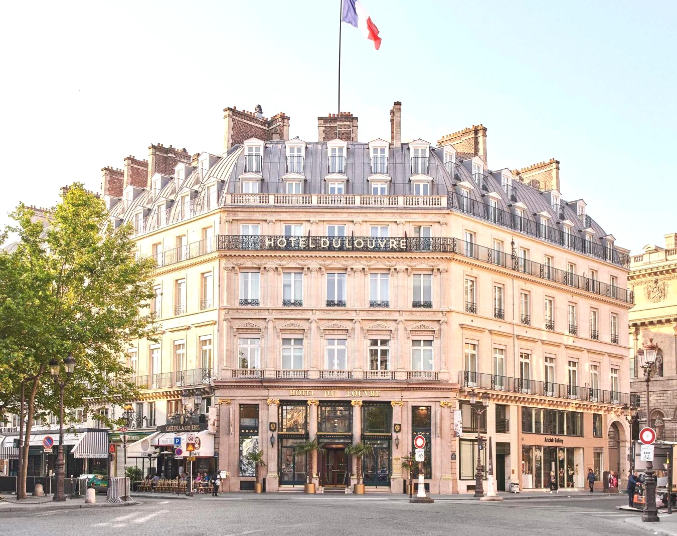 Grand bâtiment avec un drapeau en haut Hôtel du Louvre in The Unbound Collection by Hyatt à Paris