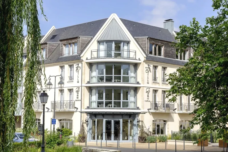 Grand bâtiment blanc avec beaucoup de fenêtres Villa Lara Hotel à Bayeux
