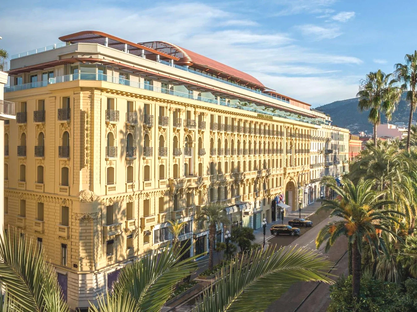 Grand bâtiment jaune avec des palmiers Anantara Plaza Nice Hotel A Leading Hotel of the World