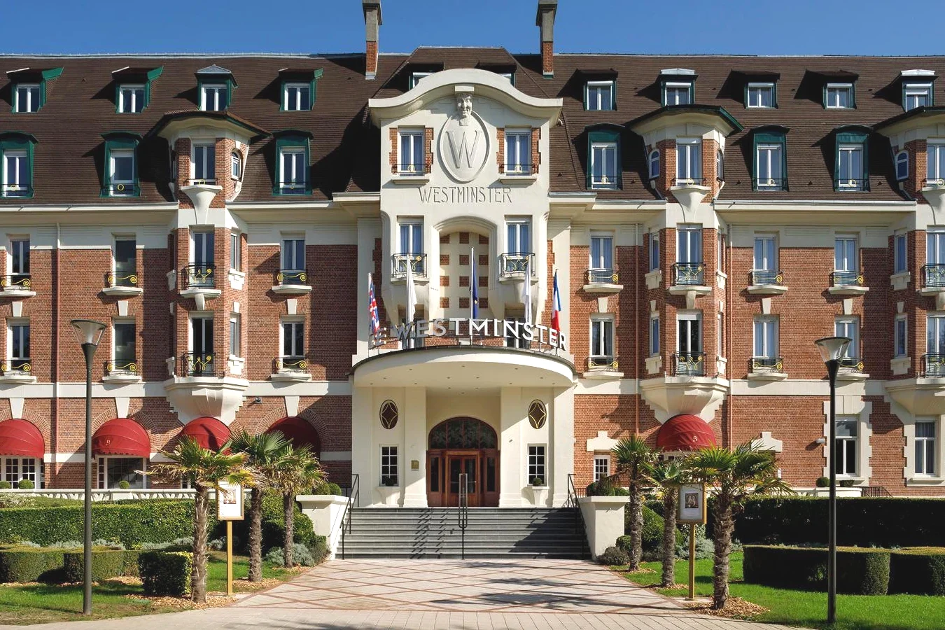 Grand bâtiment rouge et blanc Hôtel Barrière Le Westminster à Le Touquet-Paris-Plage Grand bâtiment rouge et blanc Hôtel Barrière Le Westminster à Le Touquet-Paris-Plage