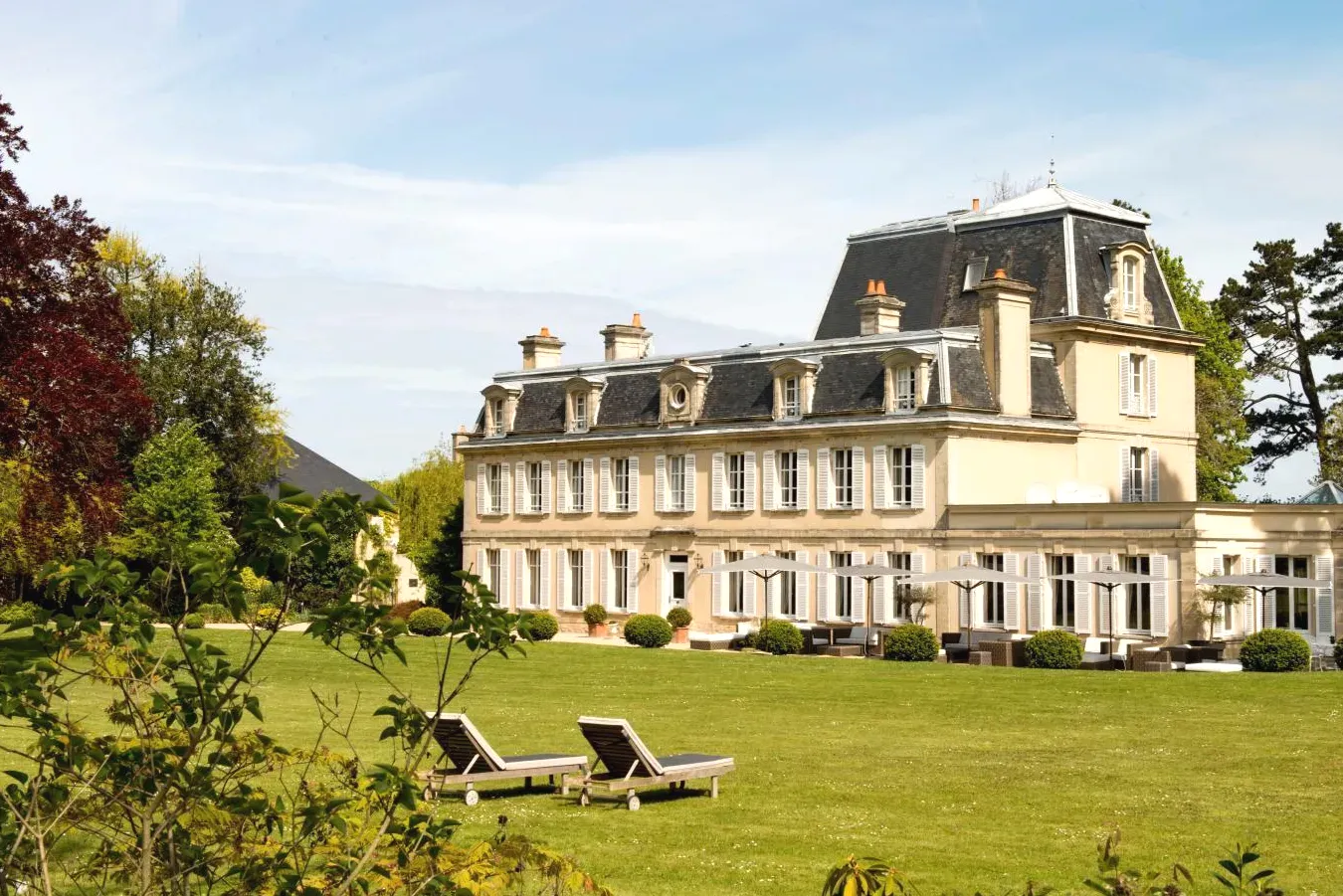 Grande maison avec deux chaises longues dans un champ Chateau La Cheneviere à Port-en-Bessin-Huppain