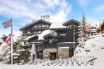 Lodge de ski avec un tas de skis dans la neige Le Lana à Courchevel