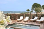 Patio avec quatre chaises et une piscine Residence Les Suites Pereire à Arcachon