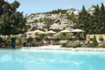 Piscine avec des chaises et des parasols en face d'une montagne Baumanière Les Baux de Provence