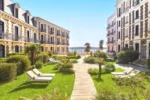 Rangée de bâtiments avec des bancs sur une promenade la mer en arrière-plan Hôtel Barrière Le Grand Hôtel Dinard