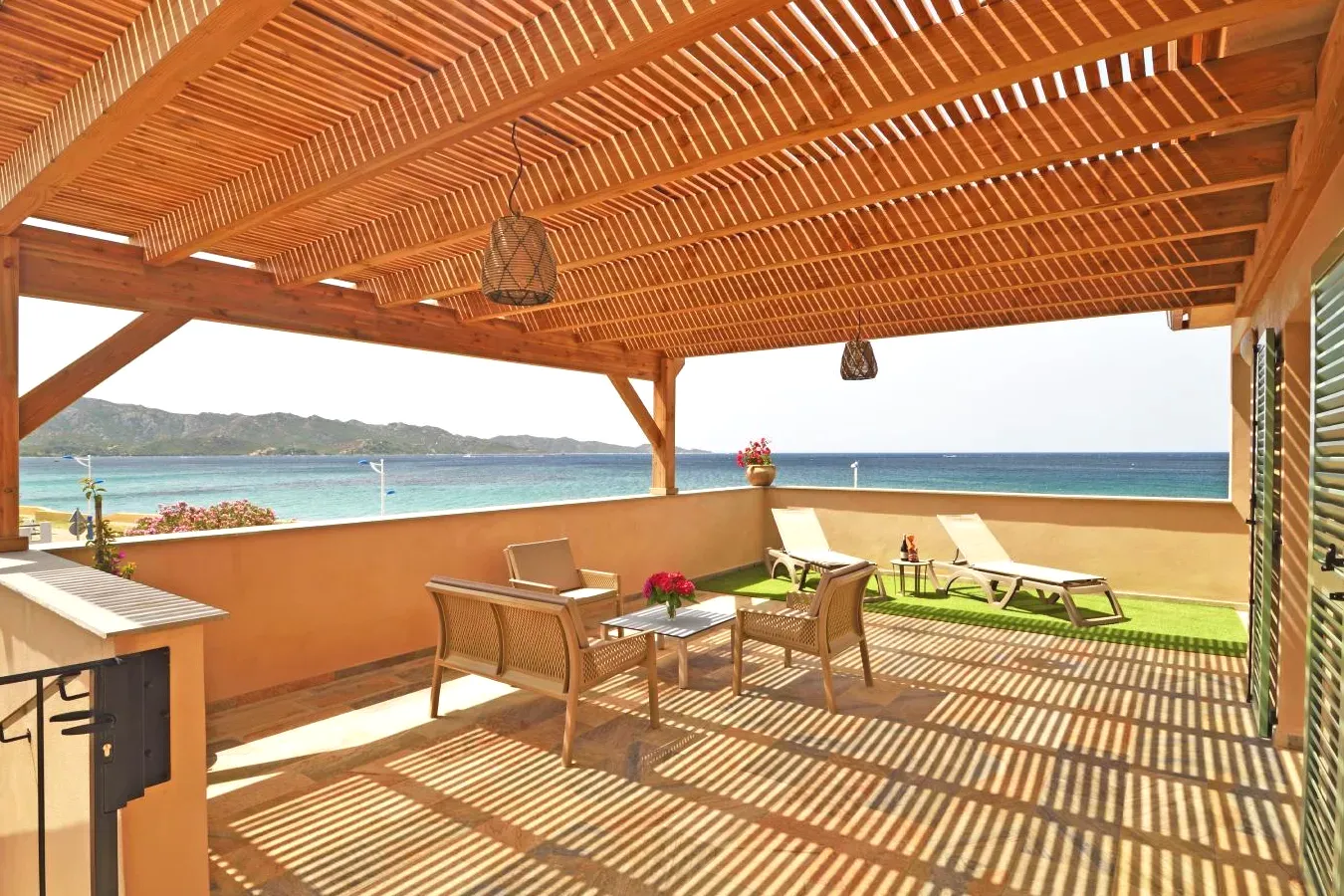 Terrasse avec une pergola en bois et la plage dans l'établissement Résidence Saint-Jean à Saint-Florent