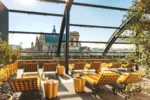 Toit-terrasse avec des chaises et des tables offrant une vue sur la ville dans Hôtel Madame Rêve à Paris