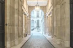 Un couloir dans un bâtiment doté d'un lustre dans l'Hôtel Alfred Sommier à Paris